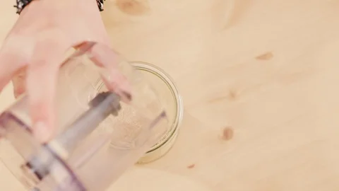 Puring bread crumbs in glass jar shot from above Stock Footage 121295500