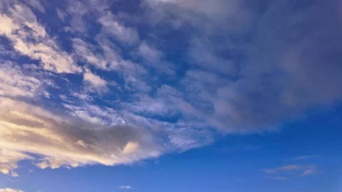 Purple and blue clouds drift across a serene sky in an early morning timelapse Stock Footage 295530466