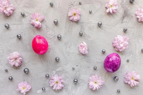 Purple and pink Easter eggs, fresh spring flowers and pearls. Trendy holiday Stock Photos