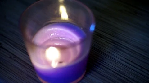 Purple candle burns in a glass on the table Stock Footage 123743993
