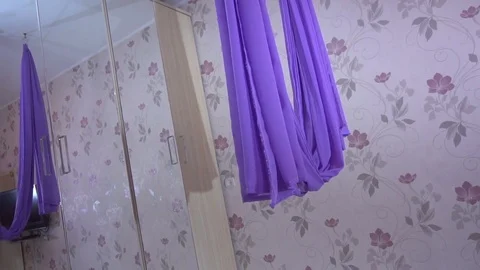 Purple cloth for practicing anti-gravity yoga in apartment Stock Footage 73492129