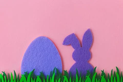 Purple Easter egg and bunny in grass on pink background, flat lay with spac.. Stock Photos