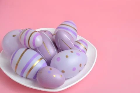 Purple Easter eggs on a plate. Pink background. Easter. Stock Photos