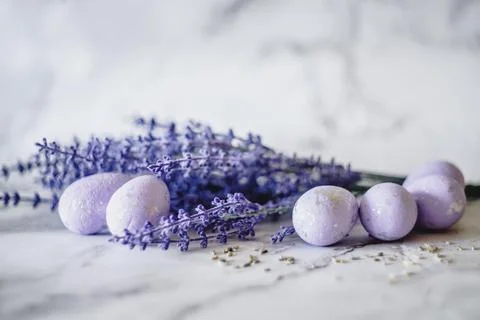 Purple Easter eggs on a table with blue lavender flowers. Stock Photos