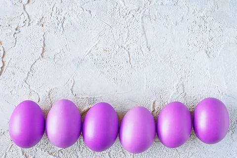 Purple easter eggs on textured background. Top view. Copy space Stock Photos