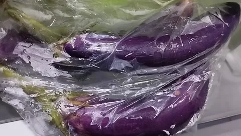 Purple eggplant in plastic wrap ready to be sold Stock Footage 229553907