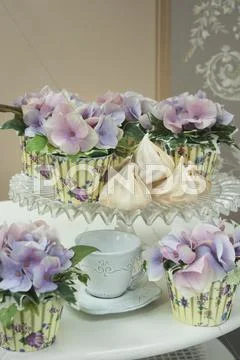 Purple Hydrangea Flowers In Pots Covered With Printed Muffin Cases On A Cake
