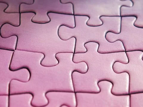 Purple jigsaw puzzle with last missing piece being placed into hole 스톡 사진