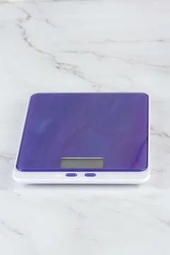 Purple kitchen scale on the kitchen table. Stock Photos