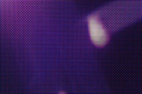 Purple LED display pixels macro photograph with soft light glare lens flare.. Illustrazione stock