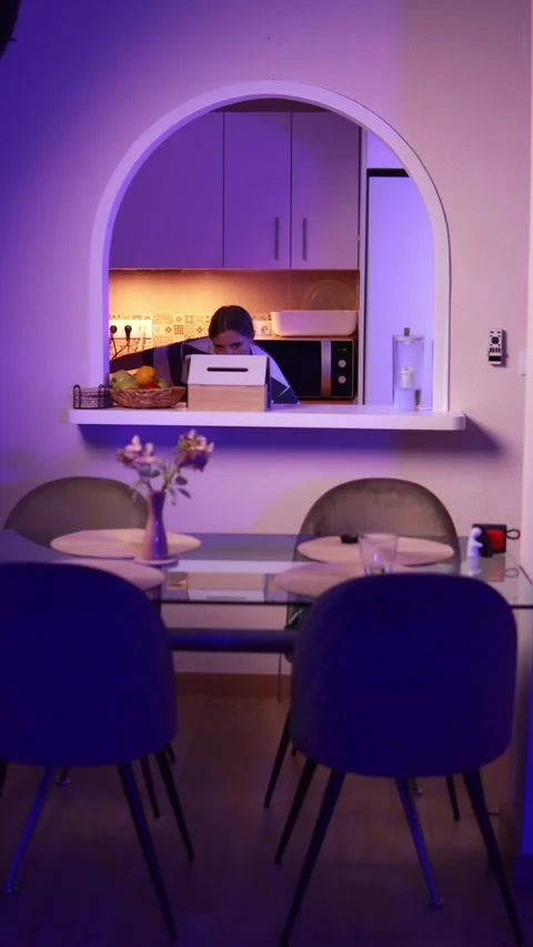 Purple lighting creating dramatic shadows in modern kitchen, woman dancing .. Stock Footage 305480340