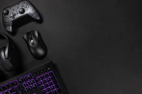 Purple lit keyboard by game controller and mouse Stock Photos