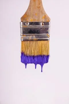 Purple paint falling downwards off of vertical paint brush Stock Photos
