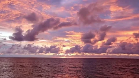 Purple pink sunset cloud on dark blue sky over calm sea water n ocean wave Stock Footage 229373294