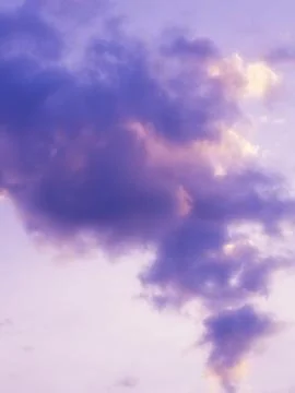 Purple puffy clouds in the sunset sky. Stock Photos