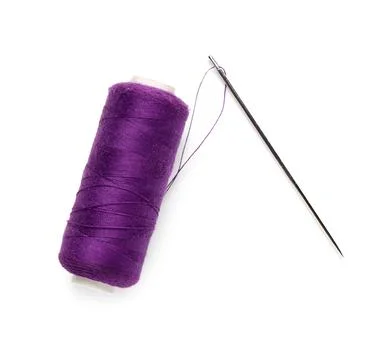 Purple sewing thread spool with needle isolated on white background, closeup Stock Photos