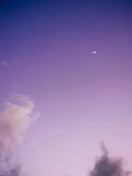 Purple sky with moon and clouds at sunset Stock Photos