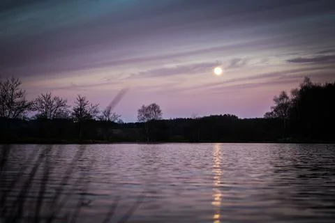 Purple sunset at full moon Stock Photos