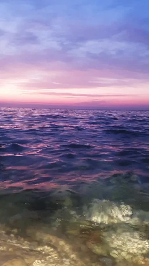 Purple Sunset View with the Ocean Waves water hitting stones on the beach Stock Footage 264963455