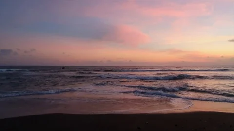 Purple sunset with waves crashing down Stock Footage 121377099