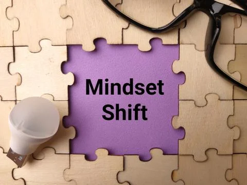 A purple text cutout displaying Mindset Shift is centered inside a wooden p.. Stock Photos