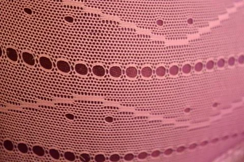 Purple thin fabric mesh is located on purple glossy fabric. Stock Photos