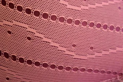 Purple thin fabric mesh is located on purple glossy fabric. Stock Photos
