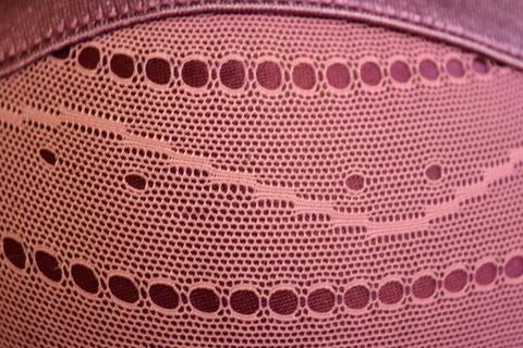 Purple thin fabric mesh is located on purple glossy fabric. Stock Photos