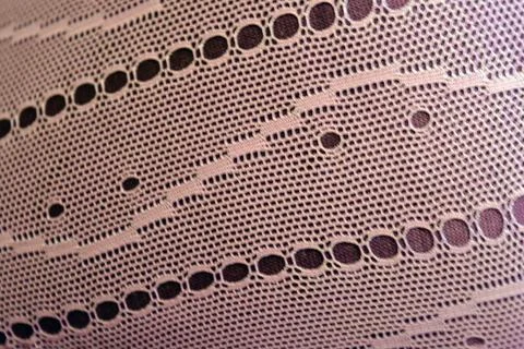 Purple thin fabric mesh is located on purple glossy fabric. Stock Photos