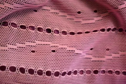 Purple thin fabric mesh is located on purple glossy fabric. Stock Photos