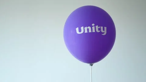 Purple unity balloon floating against white wall in slow motion dynamic stu.. Stock Footage 333154221