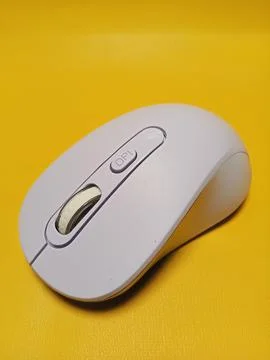 A purple wireless computer mouse isolated on yellow background Stock Photos