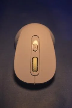 A purple wireless computer mouse isolated on blue background Stock Photos