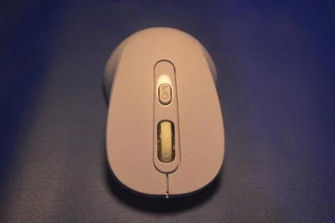 A purple wireless computer mouse isolated on blue background Stock Photos