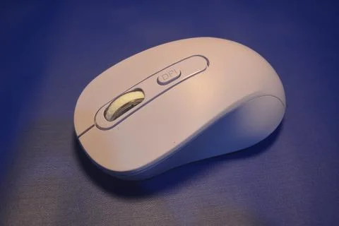 A purple wireless computer mouse isolated on blue background Stock Photos