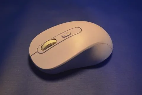 A purple wireless computer mouse isolated on blue background Stock Photos