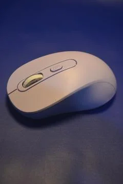 A purple wireless computer mouse isolated on blue background Stock Photos