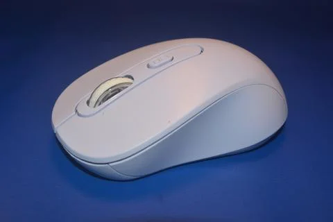A purple wireless computer mouse isolated on blue background Stock Photos