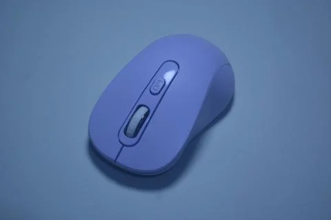 A purple wireless computer mouse isolated on pink background Stock Photos