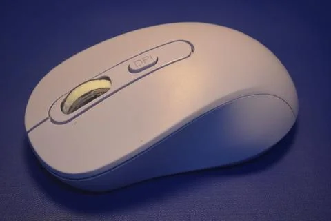 A purple wireless computer mouse isolated on blue background Stock Photos