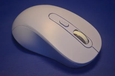 A purple wireless computer mouse isolated on blue background Stock Photos