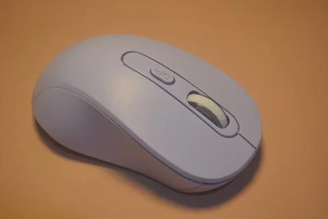 A purple wireless computer mouse isolated on pink background Stock Photos