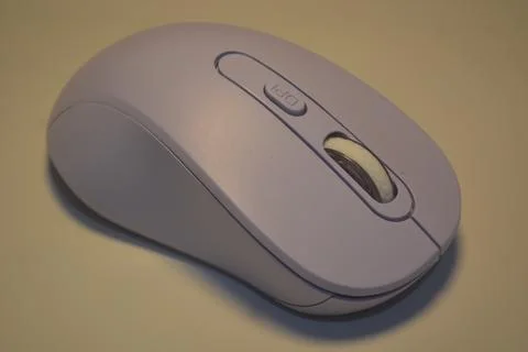 A purple wireless computer mouse isolated on pink background Stock Photos