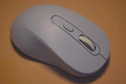 A purple wireless computer mouse isolated on pink background Stock Photos