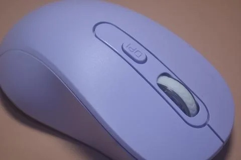 A purple wireless computer mouse isolated on pink background Stock Photos
