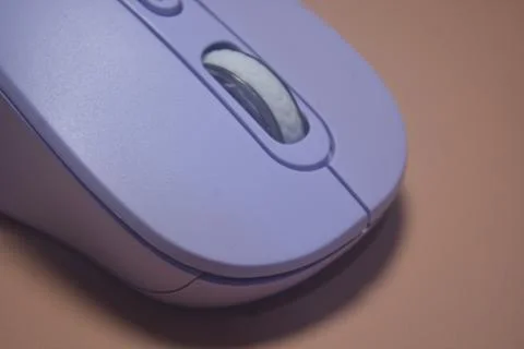 A purple wireless computer mouse isolated on pink background Stock Photos
