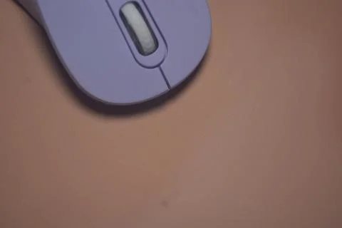 A purple wireless computer mouse isolated on pink background Stock Photos
