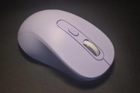 A purple wireless computer mouse isolated on black background Stock Photos