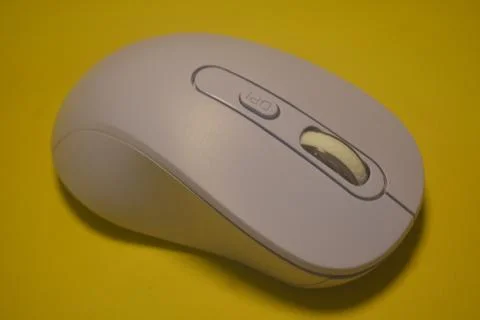 A purple wireless computer mouse isolated on yellow background Stock Photos