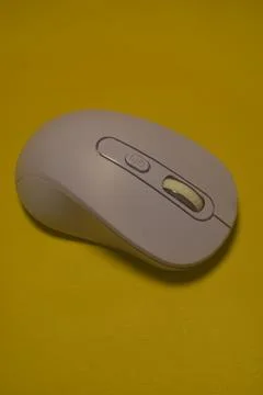 A purple wireless computer mouse isolated on yellow background Stock Photos
